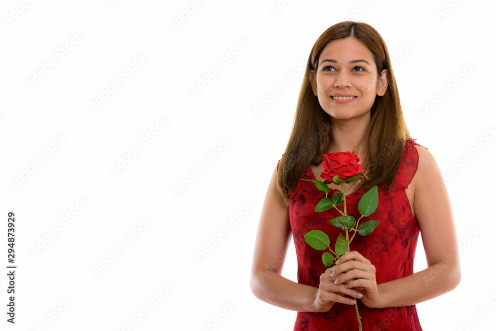 Thoughtful happy young woman smiling and holding red rose ready Thoughtful happy young woman smiling and holding red rose ready