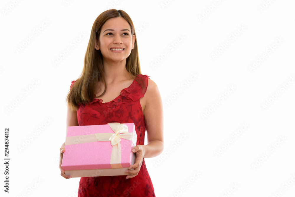 Thoughtful happy young woman smiling and holding gift box ready Thoughtful happy young woman smiling and holding gift box ready