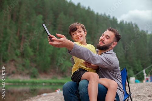 Father and son are sitting with a phone in their hands. Internet addiction