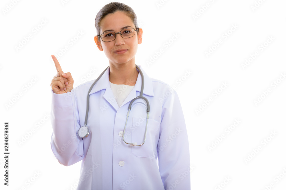Studio shot of young beautiful woman doctor pointing finger up