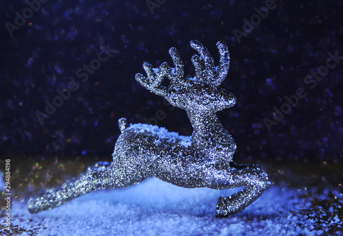 Christmas glitter deer on violet sparkling background. Neon light. Christmas concept. © Alona