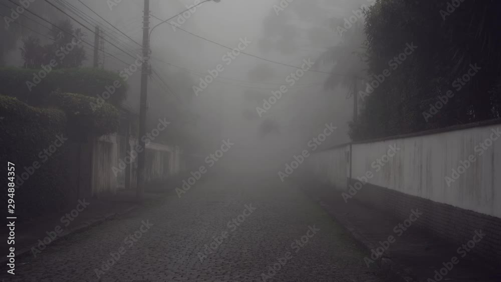 Zooming out of empty street covered with thick fog and haze