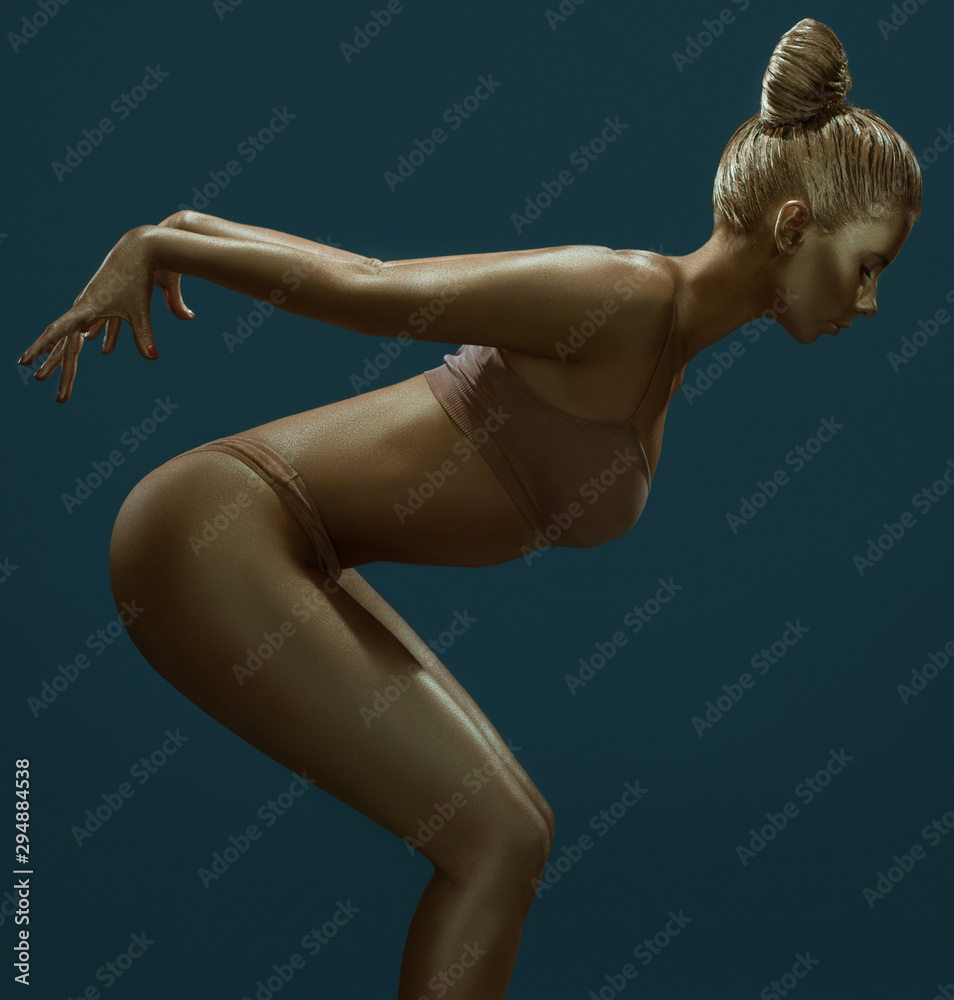 Naklejka premium Woman art portrait with gold skin in studio