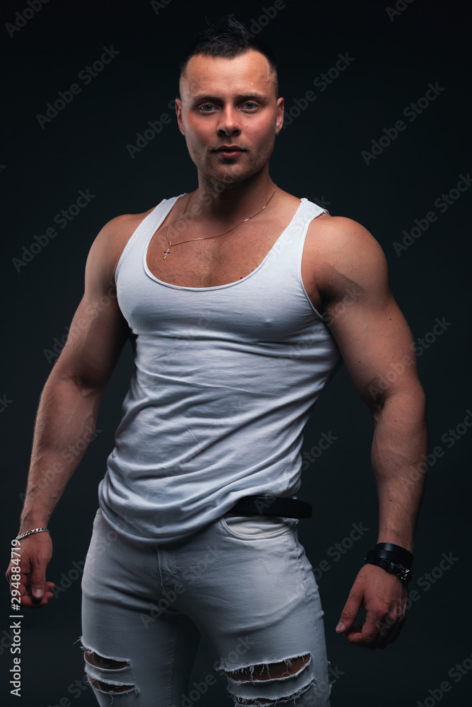 Strong and handsome young man with muscles and biceps. Studio shooting on black background. Strong and handsome young man with muscles and biceps. Studio shooting on black background.