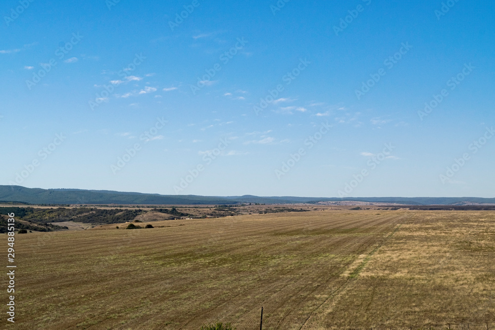 Crimean landscape. Steppe in the foreground and mountains covered with fog in the background.