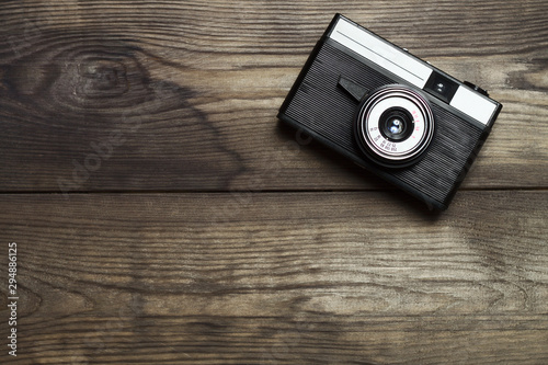 Classic film camera on wooden background.