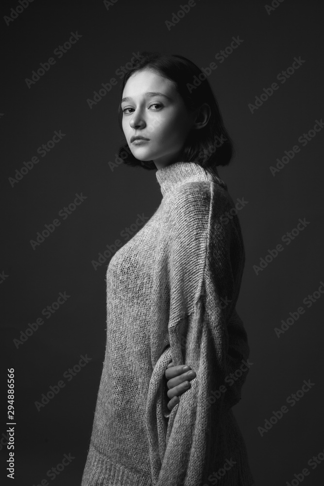 Portrait of beautiful thin young woman in sweater. Black and white