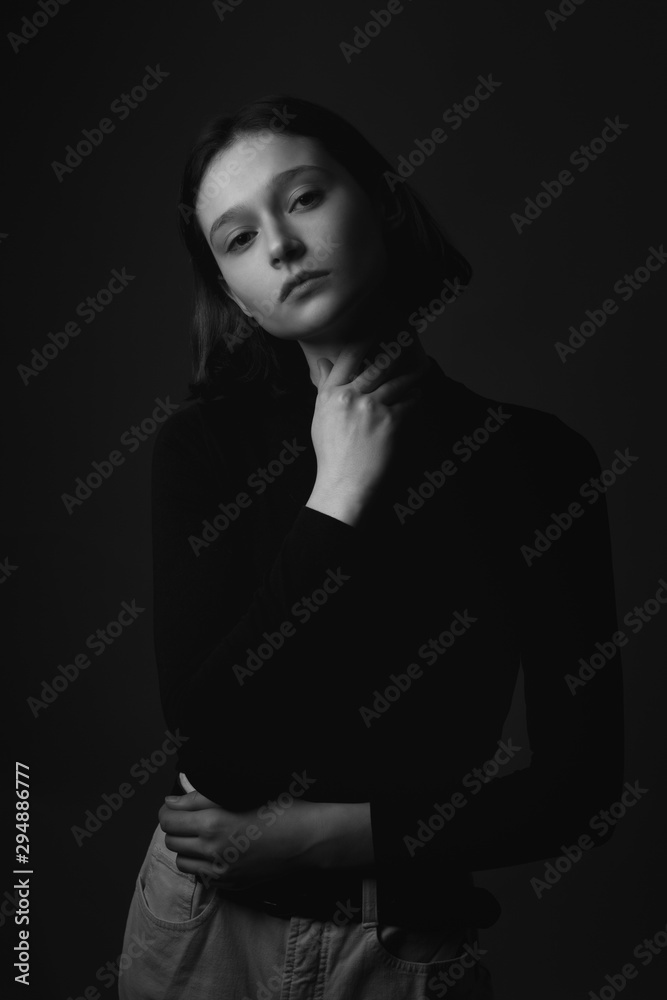 Portrait of young woman in shadows. Black and white