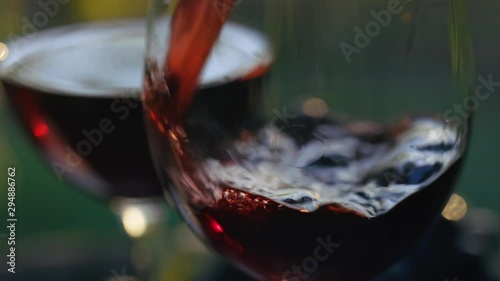 Pouring red wine into a glass, slow motion