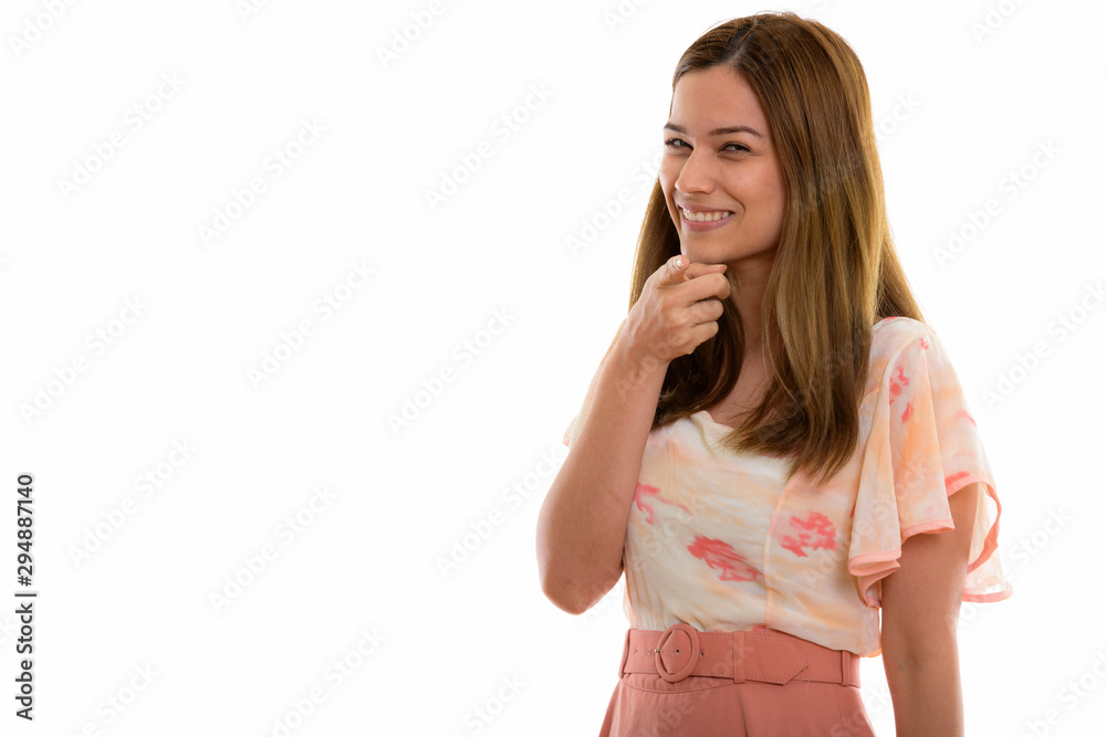 Studio shot of happy young beautiful woman smiling while pointin Studio shot of happy young beautiful woman smiling while pointin
