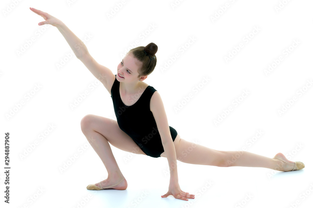 The little gymnast perform an acrobatic element on the floor. The little gymnast perform an acrobatic element on the floor.