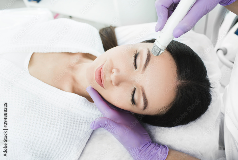 Cute Korean woman gets a face peeling procedure in a beauty salon. Skin care Cute Korean woman gets a face peeling procedure in a beauty salon. Skin care
