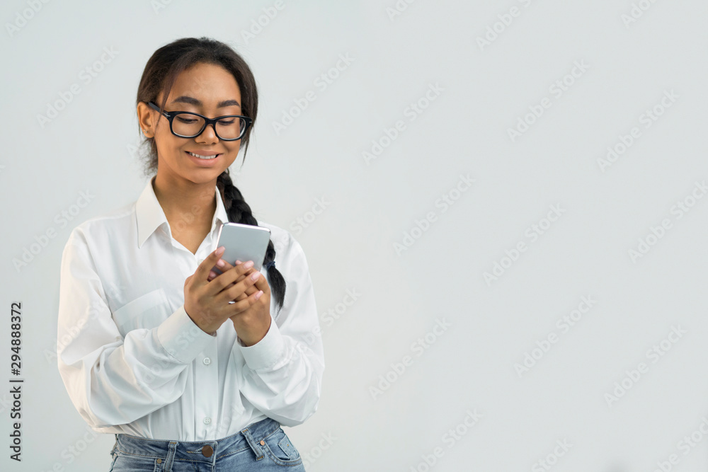 Cool application. Student girl using smartphone in studio Cool application. Student girl using smartphone in studio