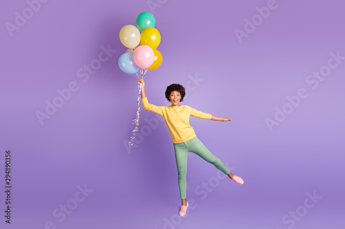 Full body photo of excited funky funny girl hold baloons flying in air try catch scream wow omg wear casual style clothing isolated over violet purple color background