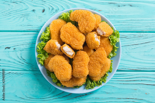 Chicken nuggets in plate on rustic background photo