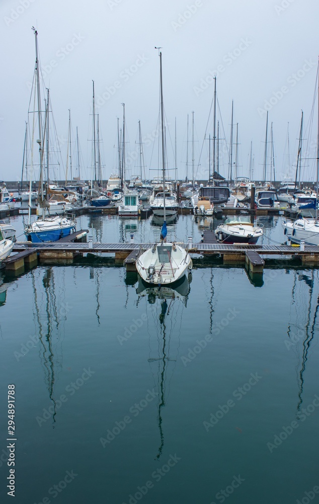 boats in marina with reflections in water