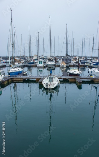 boats in marina with reflections in water