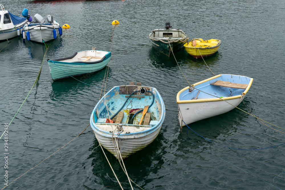 Small tender boats moored and floating at high tide in Cornwall