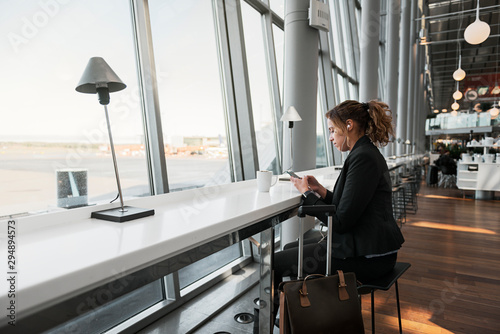 Woman using smart phone in airport