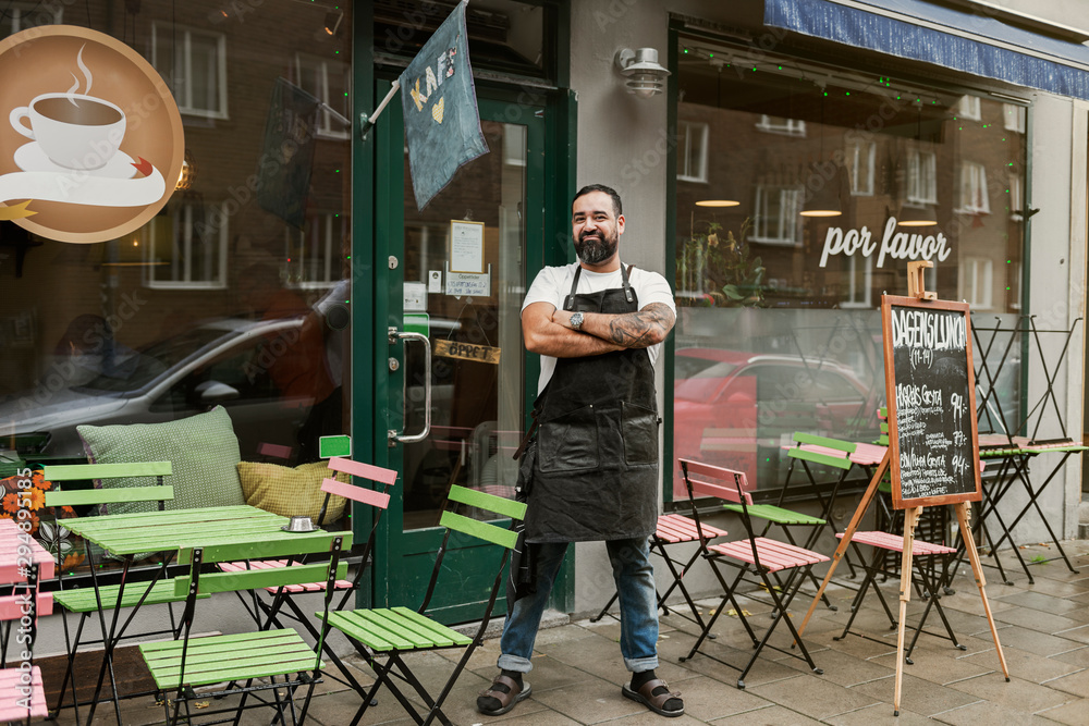Small business owner outside his cafe Small business owner outside his cafe
