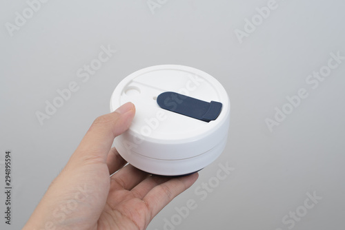 Quadro em tela Hand holding a silicon collapsible cup against a gray background.