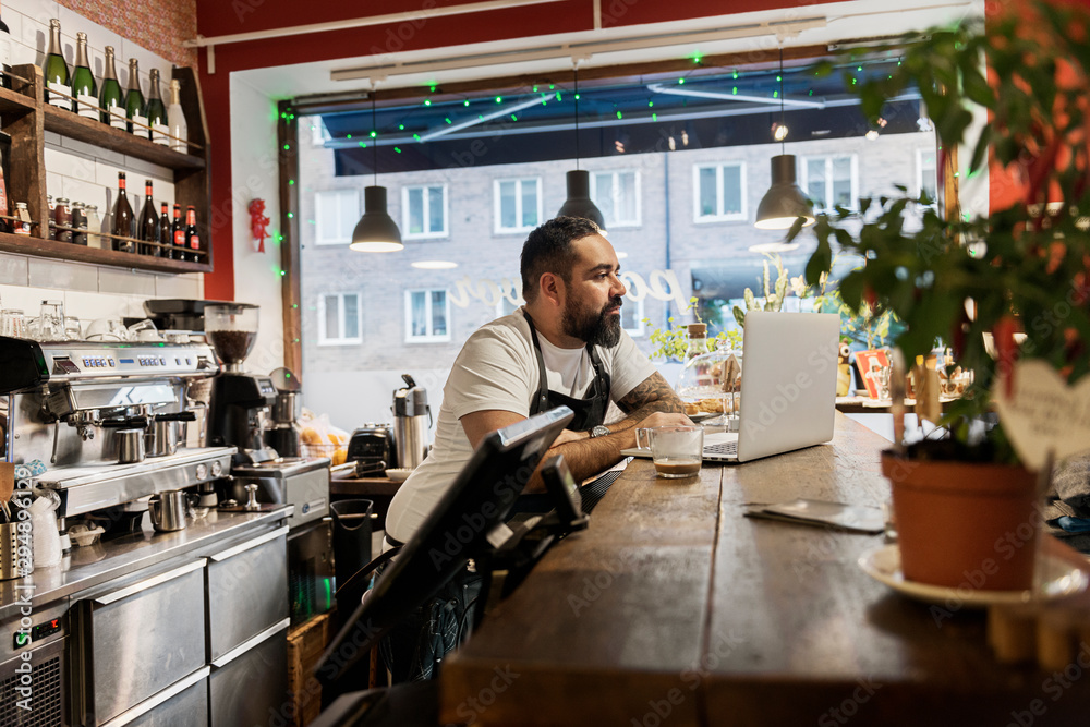 Mid adult man working in cafe Mid adult man working in cafe