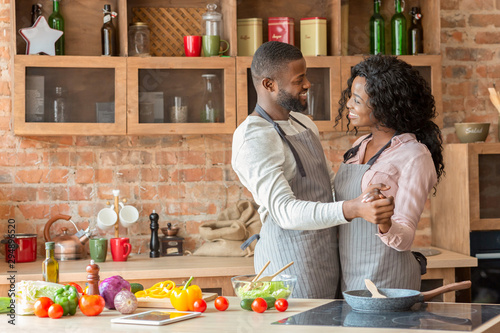 Black lovely married couple dancing in kitchen