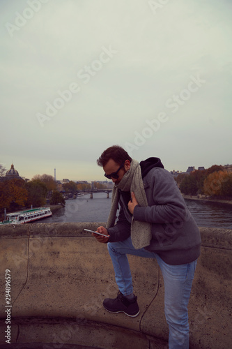Handsome man enjoying in Paris while using cellphone.