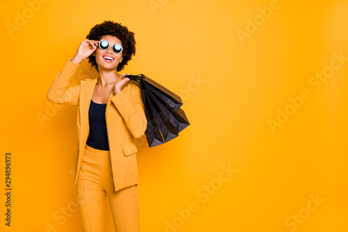 Portrait of positive cheerful lady have fun on leisure time touch specs enjoy 50 off sales bargain feel content she shopped wear style clothes pants trousers isolated yellow color background