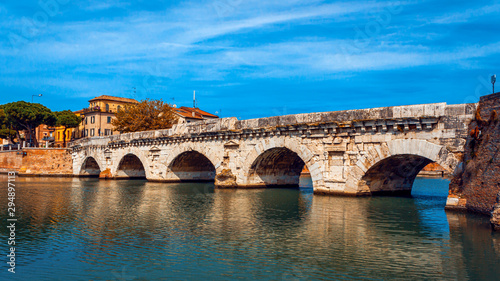 Tiberius bridge in Rimini on a background of blue sky with white clouds