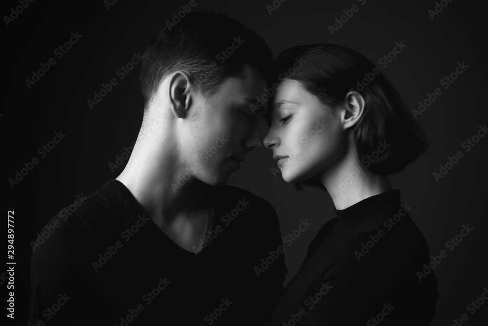 Young man and girl posing in studio. Black and white