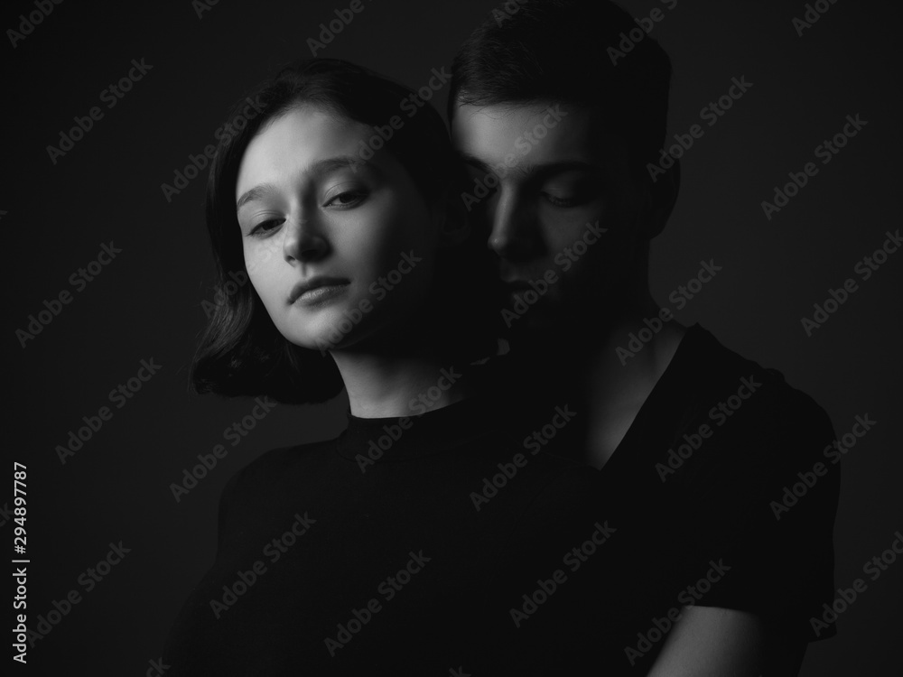 Handsome young man and girl posing in studio. Low key. Black and white Handsome young man and girl posing in studio. Low key. Black and white