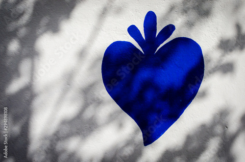 Il tipico cuore strombolano dipinto con la vernice blu su un muro photo