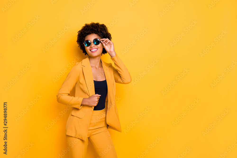 I am gorgeous. Portrait of attractive cheerful afro american lady touch her specs feel content about her beauty wear fashionable clothing isolated over yellow bright color background I am gorgeous. Portrait of attractive cheerful afro american lady touch her specs feel content about her beauty wear fashionable clothing isolated over yellow bright color background