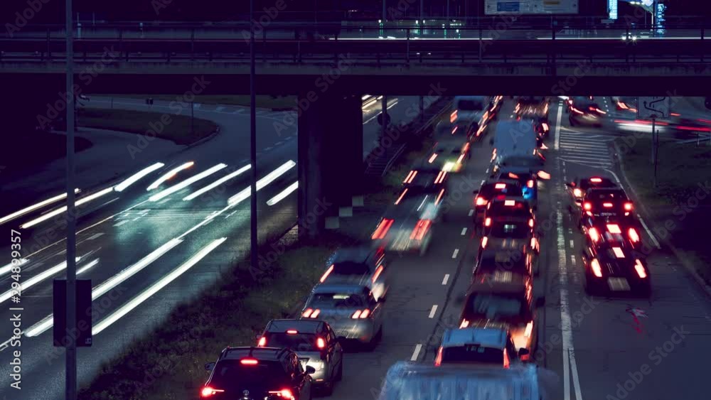 Closeup timelapse of car traffic jam busy highway road during evening dusk in bavaria munich night time light trail