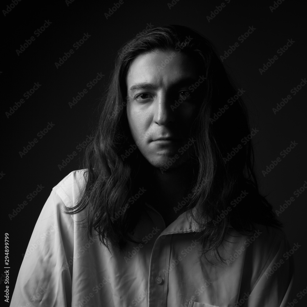 Serious young man in studio. Black and white