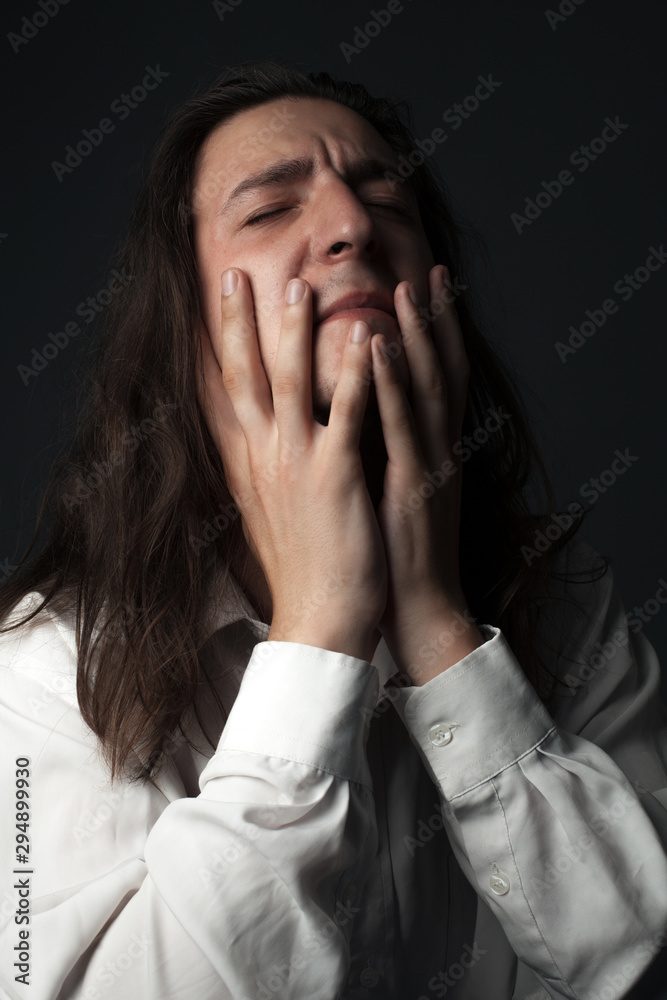 Portrait of young man in despair. Hands on face Portrait of young man in despair. Hands on face
