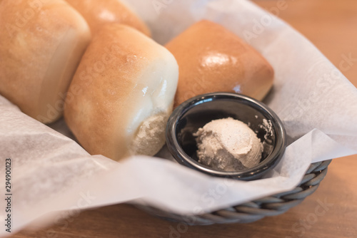 Texas Roadhouse Rolls with Cinnamon Honey Butter in a basket.; photo