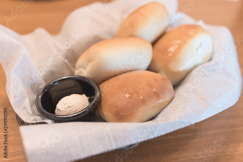 Texas Roadhouse Rolls with Cinnamon Honey Butter in a basket.; photo