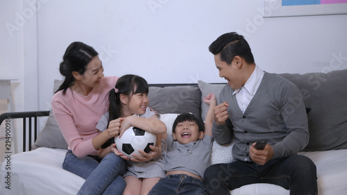 Family concept. Parents and children cheering football together in the house. 4k Resolution.