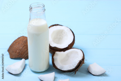 Milk and broken coconuts on the table. Vegetable milk, a veggie drink.