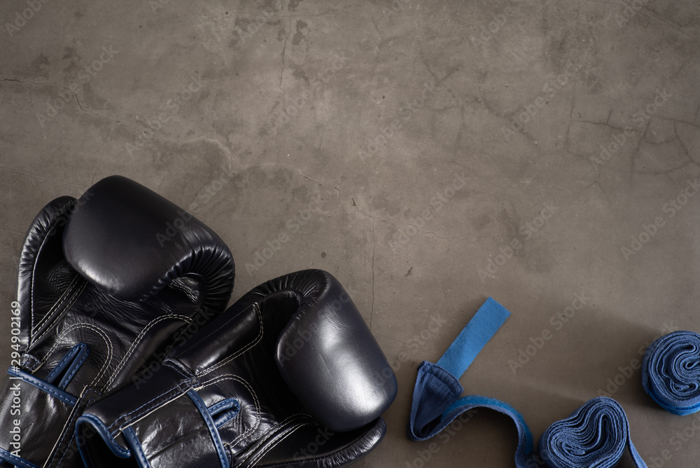 Navy Blue Boxing gloves and a pair of boxer hand wraps on an industrial