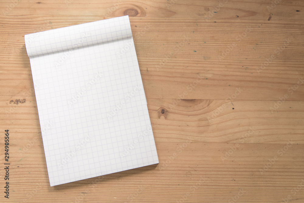 Mock up open blank grid notepad on a wooden table. Mock up open blank grid notepad on a wooden table.