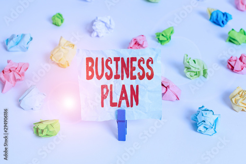 Handwriting text Business Plan. Conceptual photo Structural Strategy Goals and Objectives Financial Projections Colored crumpled papers empty reminder white floor background clothespin © Artur