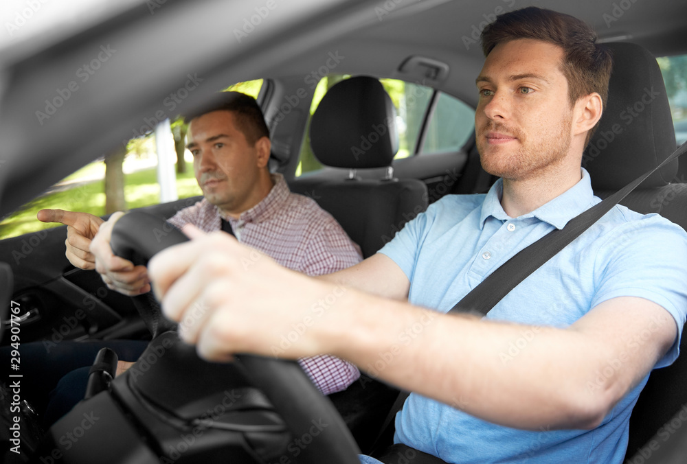 driver courses and people concept - car driving school instructor teaching young man to drive