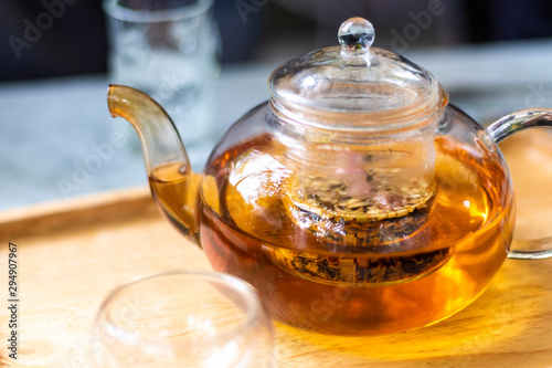 Hot water with tea leaves in teapot and cup on the table .Process brewing tea,tea ceremony,Cup of freshly brewed tea,The Time of Tea Break.