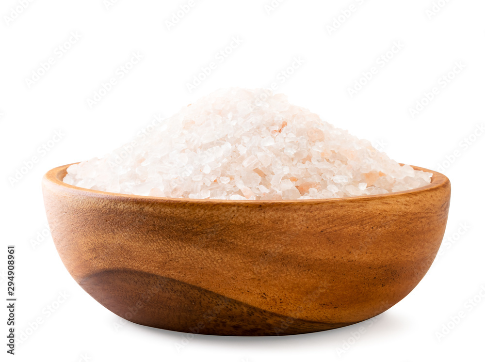 Pink salt in a wooden plate close-up on a white background. Pink salt in a wooden plate close-up on a white background.
