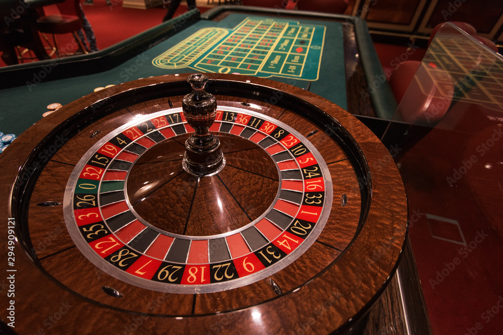 Casino, gambling and entertainment concept - roulette table and stack of poker chips Casino, gambling and entertainment concept - roulette table and stack of poker chips