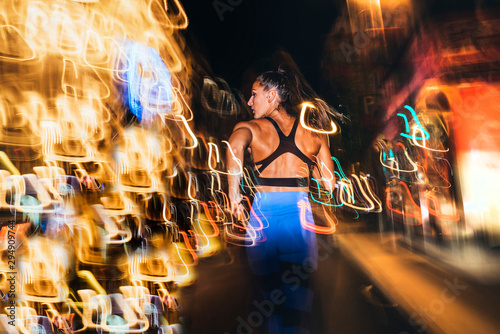 Woman running in the city with flashing lights at night