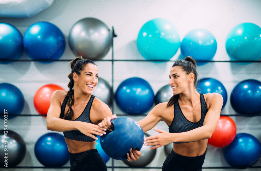 Twin sisters in gym practicing with a ball Twin sisters in gym practicing with a ball